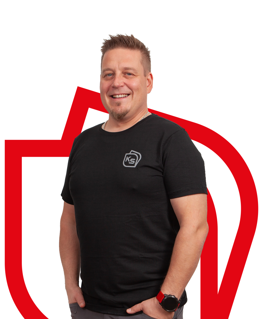 Tummahiuksinen mieshenkilö kädet taskuissa katsoo suoraan kohti ja hymyilee, taustalla on punaisella yrityksen logon ääriviivat.