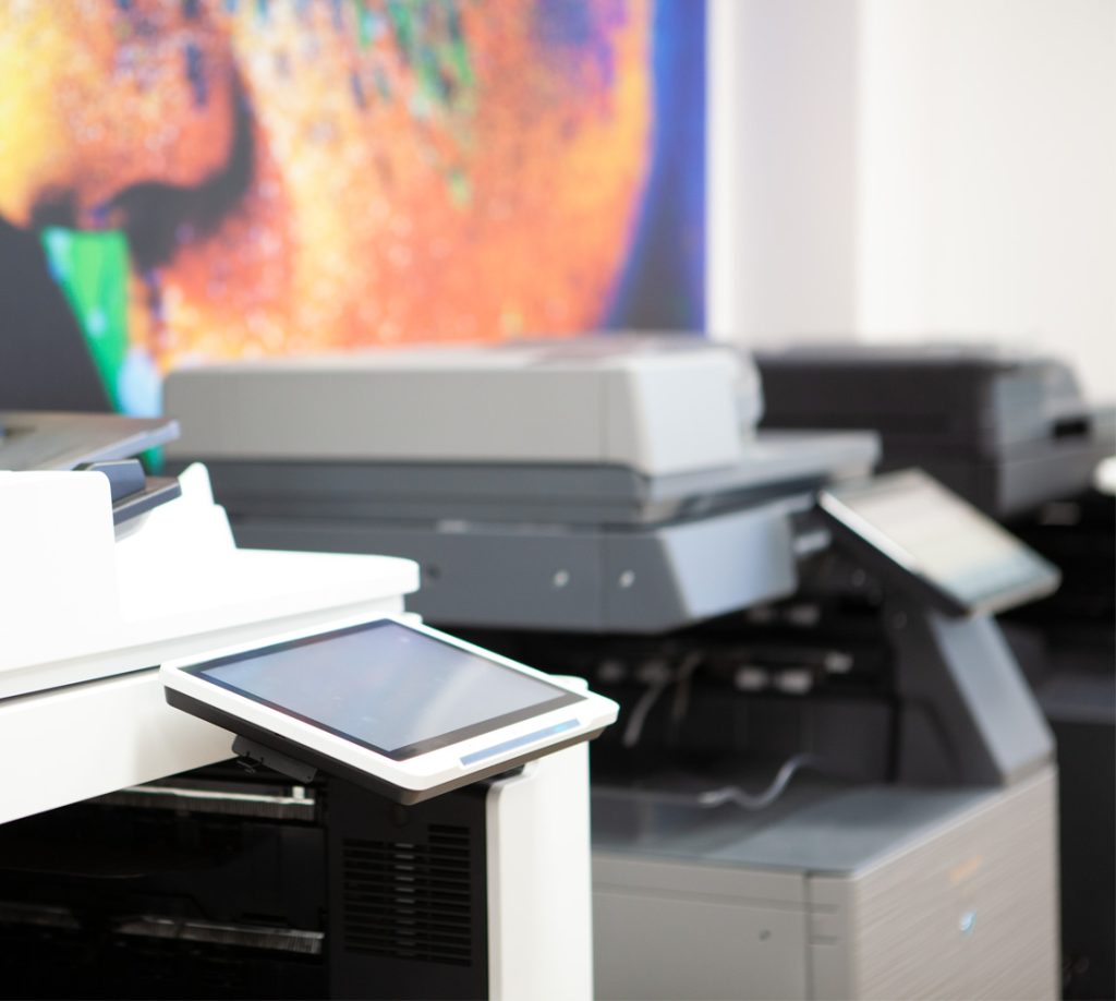 Tarkalla rajauksella läheltä kuvattuna kolme erilaista ja erimerkkistä monitoimilaitetta. Canon, Sharp ja Konica Minolta merkkiset monitoimilaitteet.